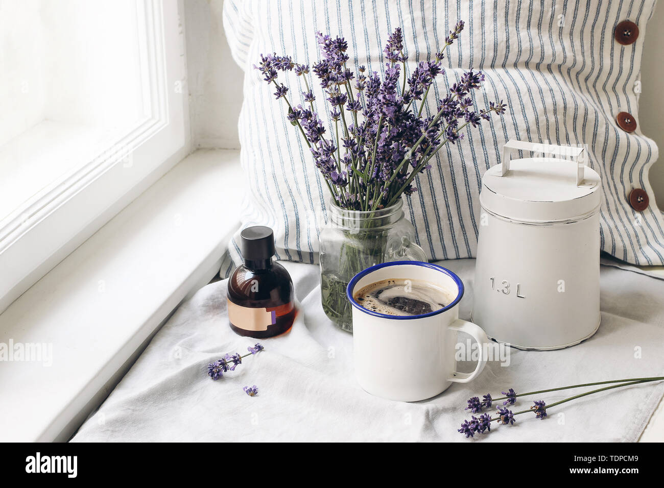 Französische Sommer noch leben. Tasse Kaffee, Lavendel Blumen Blumenstrauß, Essence öl Flasche auf der Fensterbank. Feminin Foto, blumige Komposition w Stockfoto