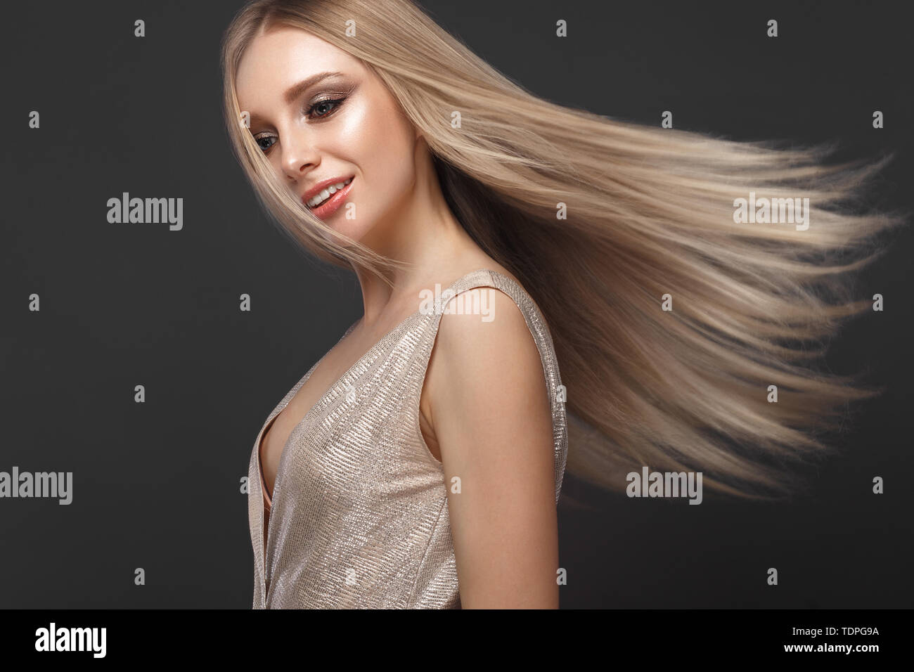 Schöne blondes Mädchen in bewegen perfekt glattes Haar mit klassischen Make-up. Beauty Gesicht. Stockfoto