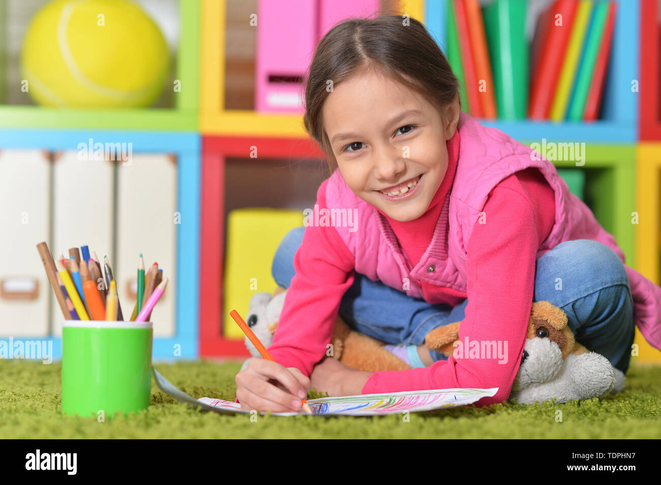 Portrait von niedlichen kleinen Mädchen sitzt auf dem Boden Stockfoto