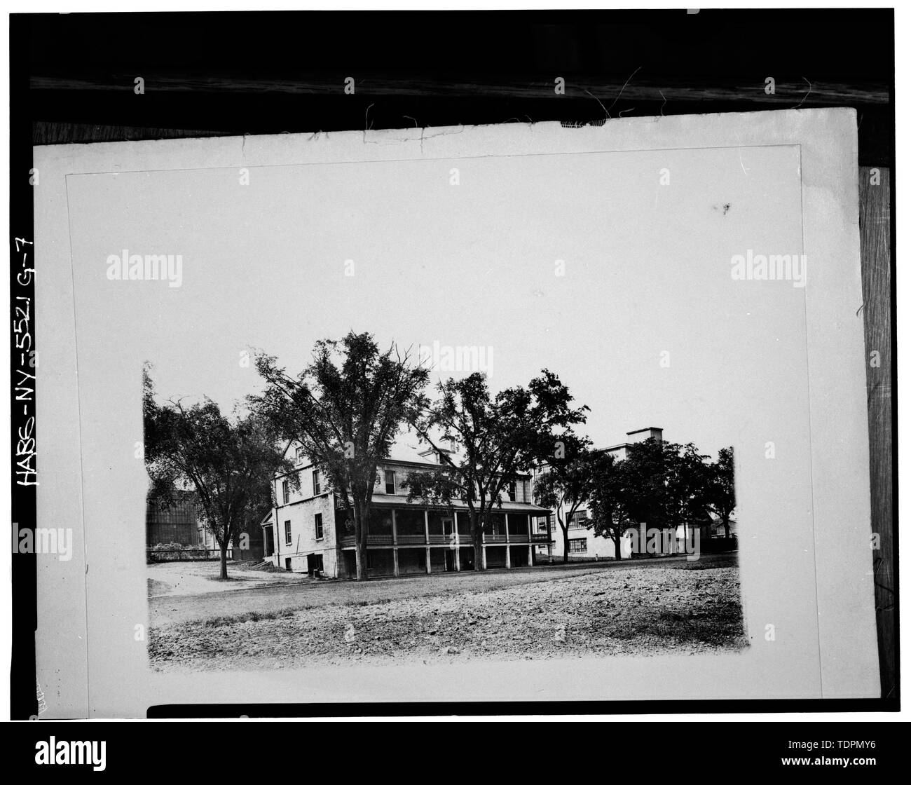 Foto von einem Foto in Besitz der Watervliet Arsenal Museum, New York. Im Süden und Osten ERHÖHUNGEN VOR DEM AUSBAU VON PORCHES UND GAUBEN. Gebäude 23 IST AUF DER RECHTEN SEITE. Genommen zwischen etwa 1918 und 1940. - Watervliet Arsenal, Gebäude Nr. 24, Arnold Lane, südlich von westervelt Avenue, Watervliet, Albany County, NY Stockfoto
