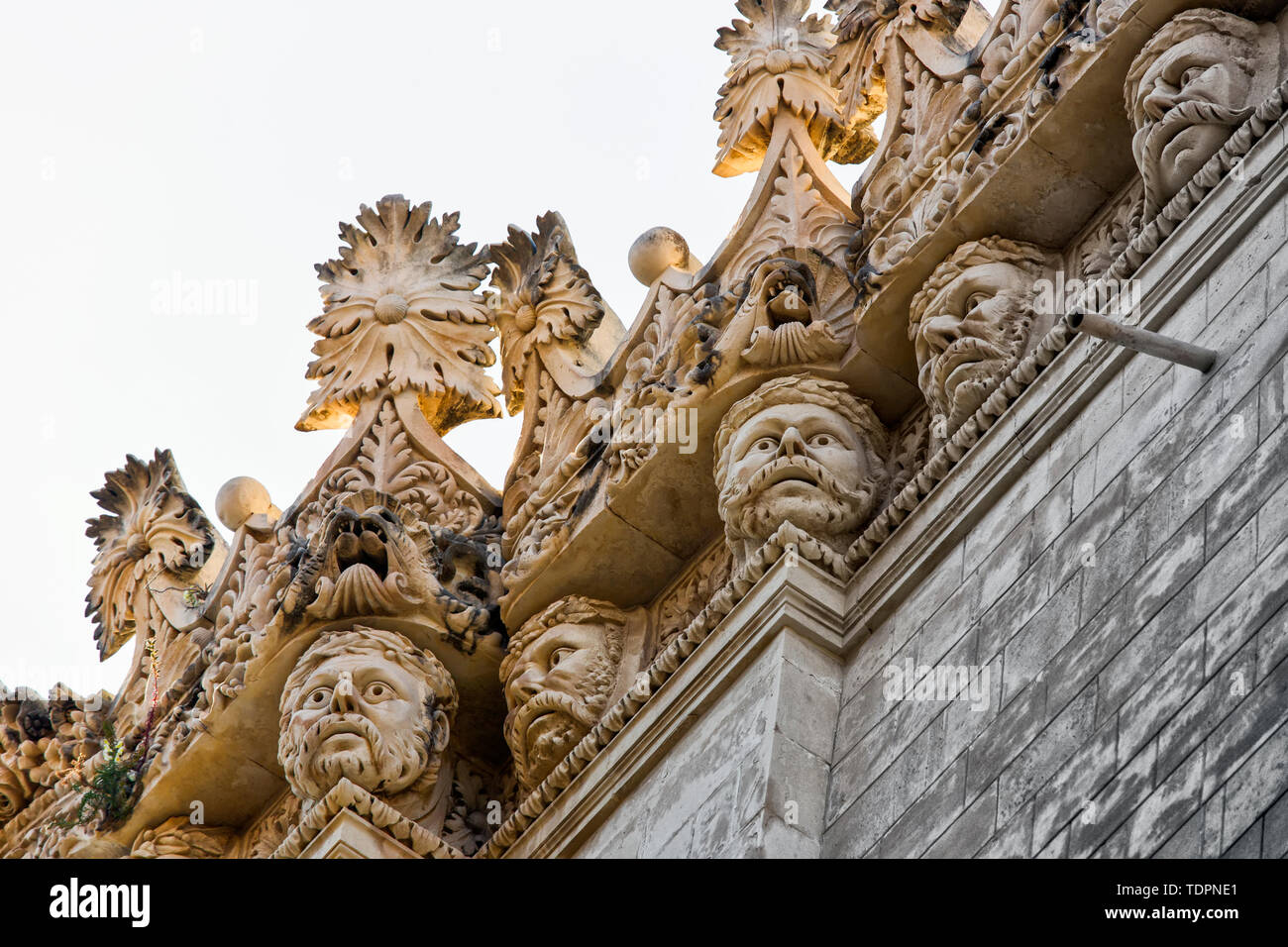 Dekorative Dachlinie eines Gebäudes mit menschlichen Gesichtern, Syrakus, Sizilien, Ortigia, Italien Stockfoto