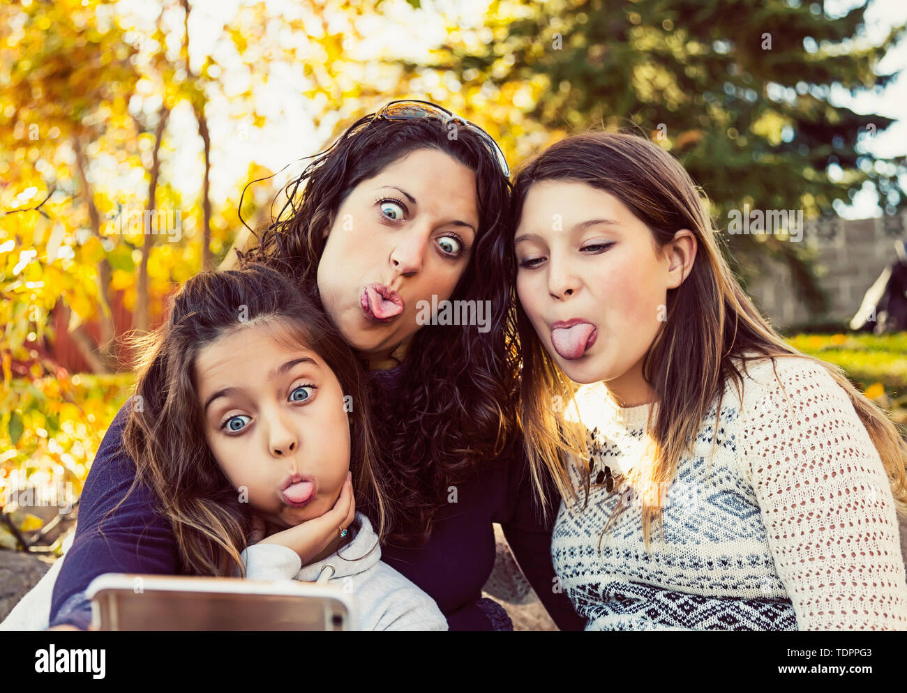 Eine Mutter und ihre zwei Töchter, ein Selbstportrait, während Sie bei einem Familienausflug in einem Stadtpark an einem warmen Herbst Tag; Edmonton, Alberta, Kanada Stockfoto