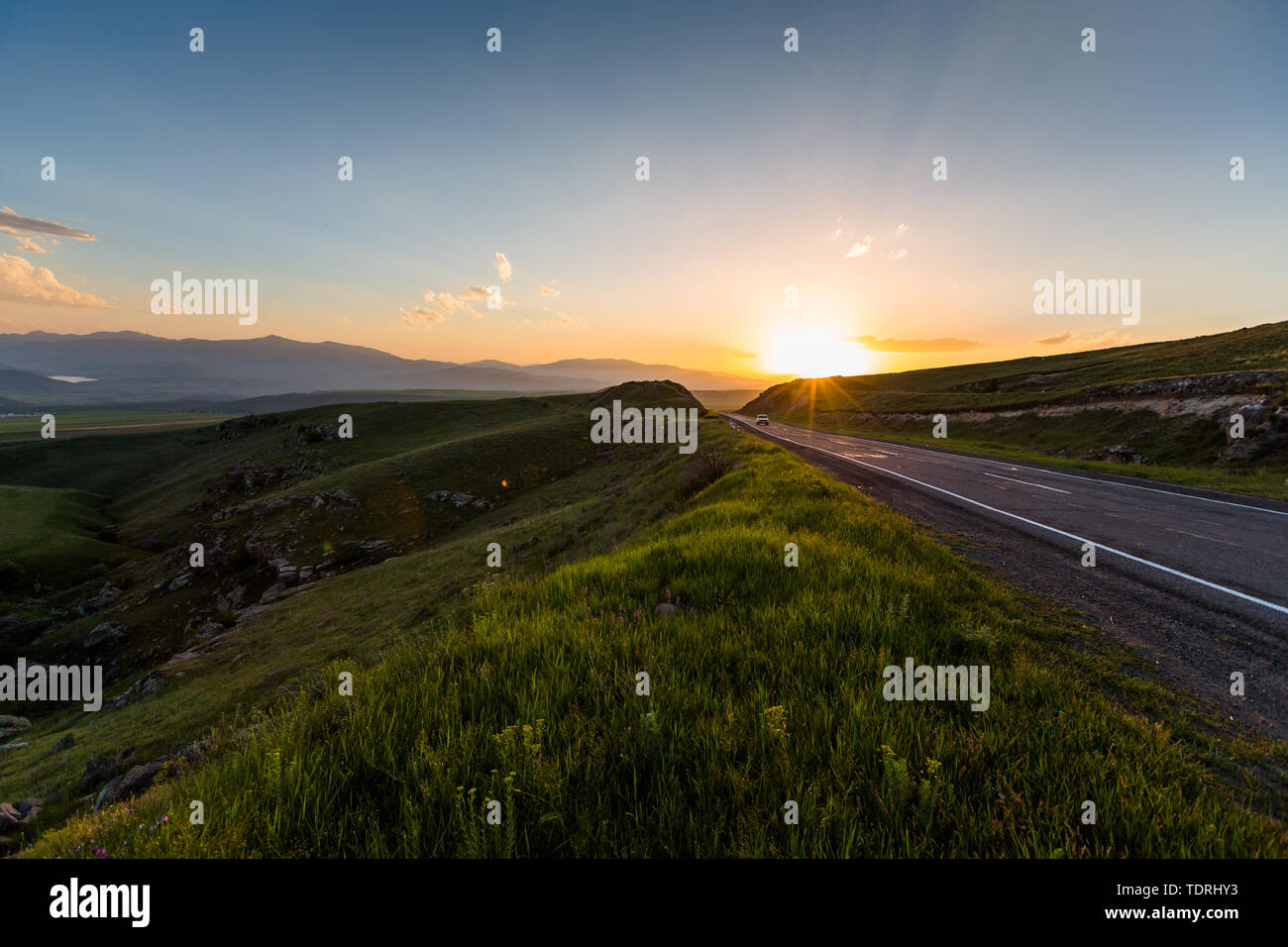 Straße in der Nähe der Berge bei Sonnenuntergang Stockfoto