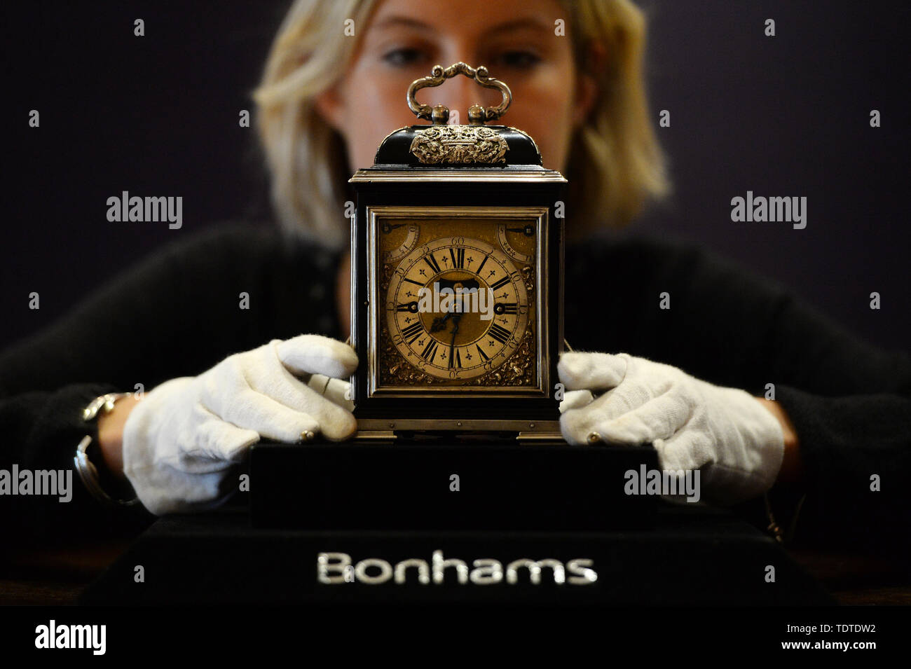 Eine Gallery Assistant betrachtet die King William & Queen Mary Royal Tompion, eine der wertvollsten Uhren der Welt, der eingestellt wird, um an der Auktion durch Bonhams heute angeboten werden. Die tischuhr von uhrmachermeister Thomas Tompion für Queen Mary II. im Jahre 1693 wird voraussichtlich mehr als £ 2.000.000 zu holen. Stockfoto