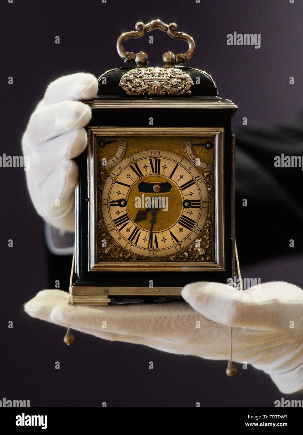 Eine Gallery Assistant hält die King William & Queen Mary Royal Tompion, eine der wertvollsten Uhren der Welt, der eingestellt wird, um an der Auktion durch Bonhams heute angeboten werden. Die tischuhr von uhrmachermeister Thomas Tompion für Queen Mary II. im Jahre 1693 wird voraussichtlich mehr als £ 2.000.000 zu holen. Stockfoto
