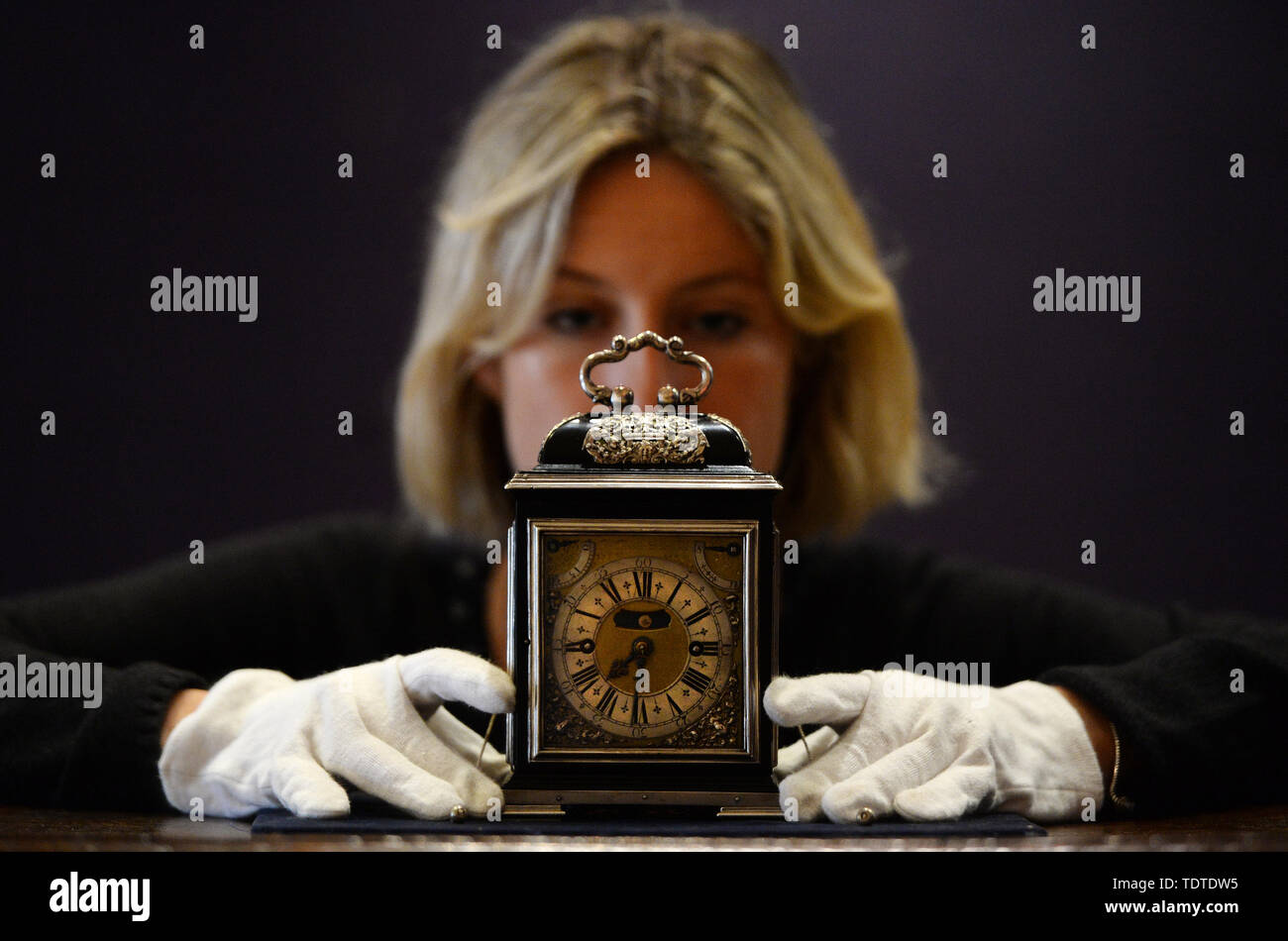 Eine Gallery Assistant betrachtet die King William & Queen Mary Royal Tompion, eine der wertvollsten Uhren der Welt, der eingestellt wird, um an der Auktion durch Bonhams heute angeboten werden. Die tischuhr von uhrmachermeister Thomas Tompion für Queen Mary II. im Jahre 1693 wird voraussichtlich mehr als £ 2.000.000 zu holen. Stockfoto