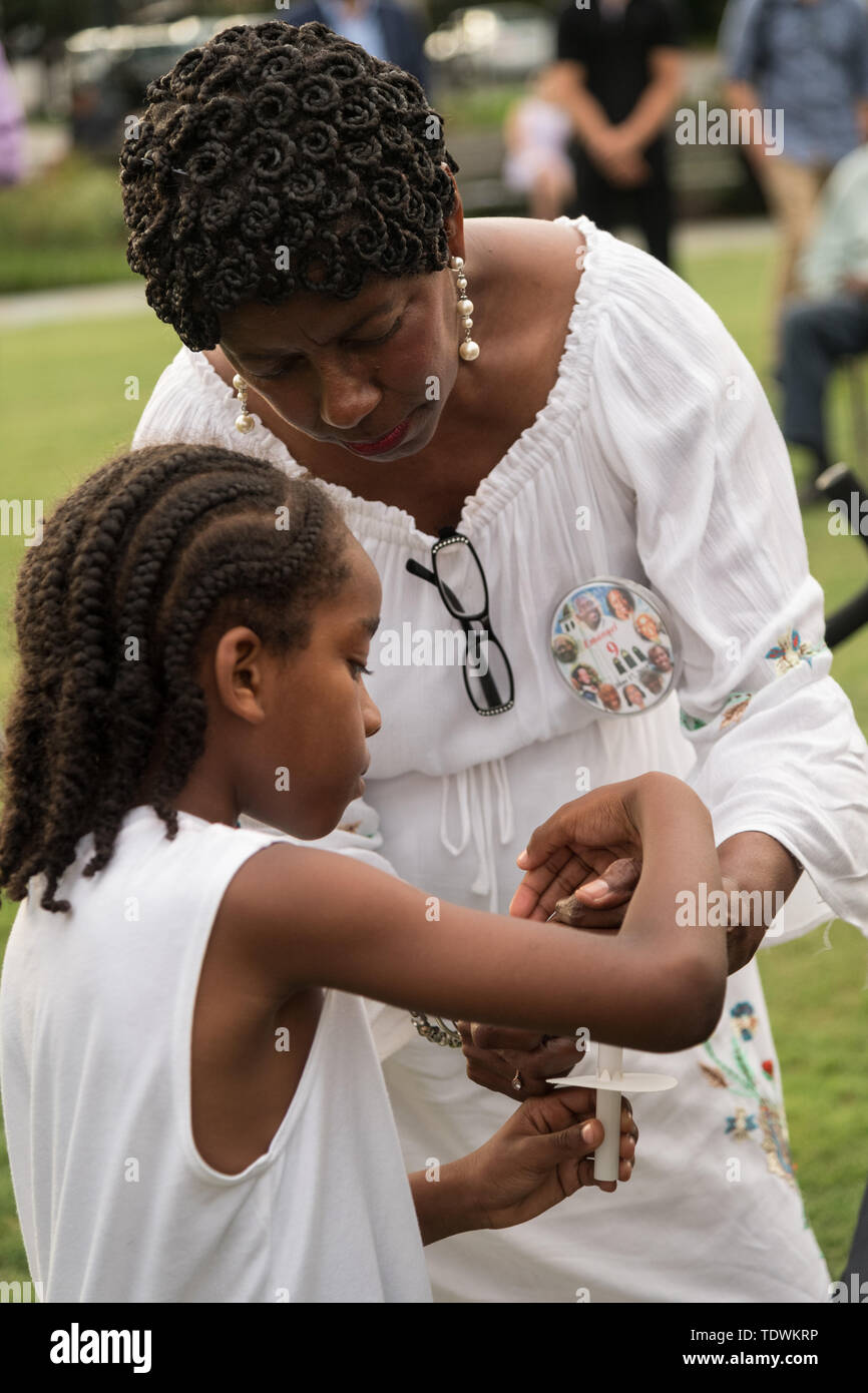 Charleston, USA. Juni, 2019 19. Verwandten der Emanuel 9, in einer Masse auf den historischen Mutter Emanuel Afrikanische Methodistisch-Bischöfliche Kirche getötet, eine Kerze im Beten für Amerika service Kennzeichnung der 4. Jahrestag der Massenerschießungen Juni 19, 2019 in Charleston, South Carolina. Neun Mitglieder der historisch schwarzen Gemeinde wurden während der bibelarbeit durch ein weißes supremacist am 17. Juni 2015 geschossen. Credit: Planetpix/Alamy leben Nachrichten Stockfoto