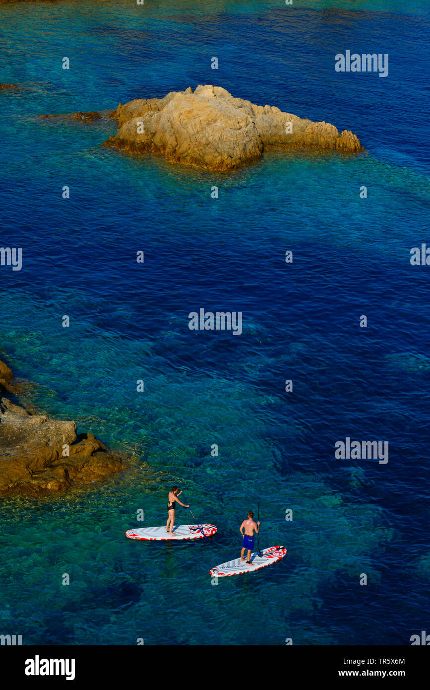 Standup paddleboarding an der felsigen Küste von Ile Rousse, Frankreich, Korsika, Ile Rousse Stockfoto