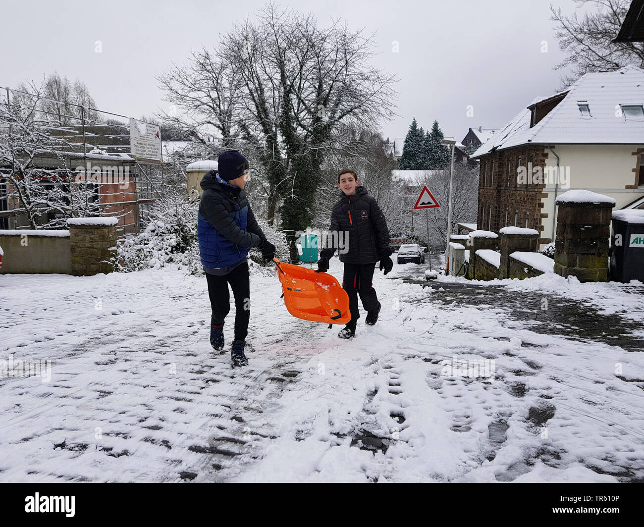 Kinder mit Ski Bob auf einer Straße, Deutschland, Nordrhein-Westfalen, Ruhrgebiet, Witten Stockfoto