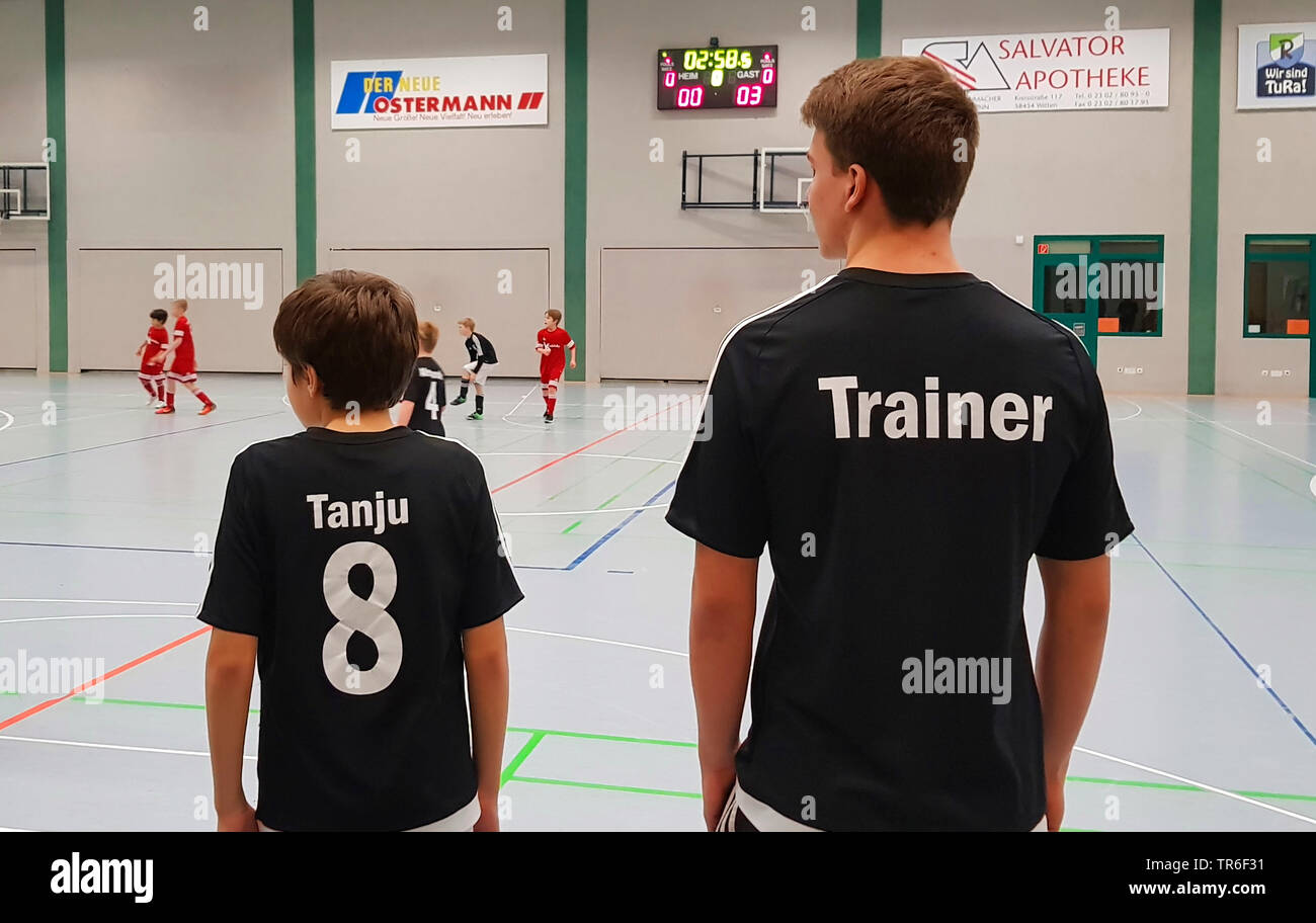 Junge und coacher in einer Sporthalle bei socker Spiel, Deutschland Stockfoto