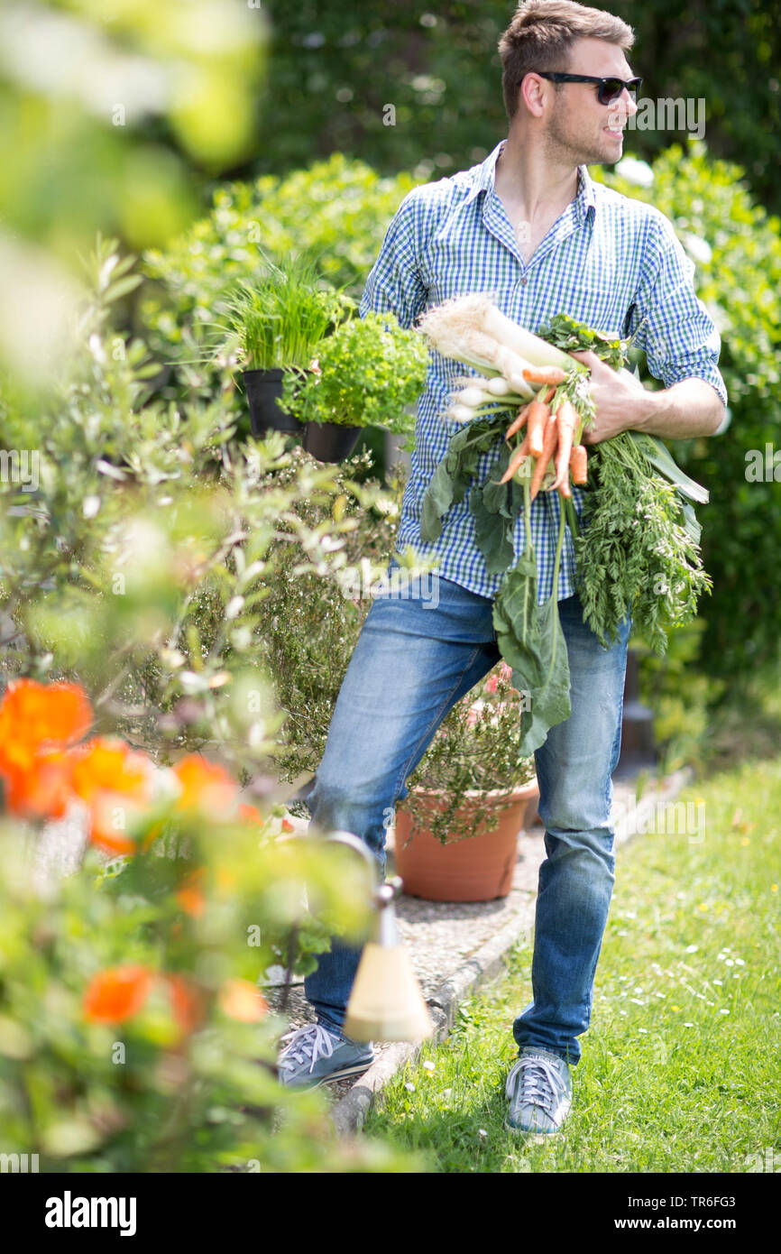Junger Mann mit Gemüse aus dem eigenen Garten, Deutschland Stockfoto