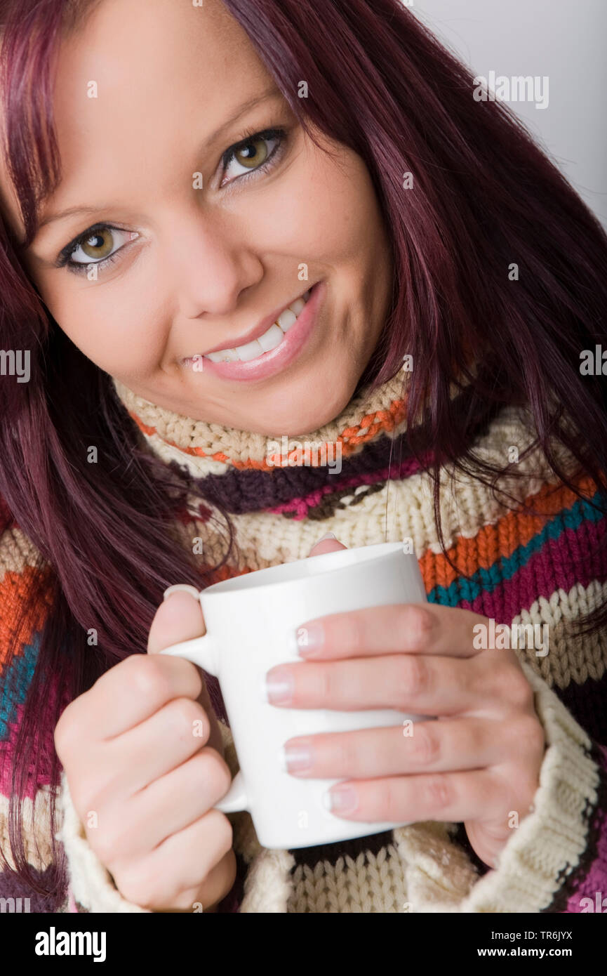 Junge, rothaarige Frau in Rollkragen-pullover mit Tasse Tee Stockfoto