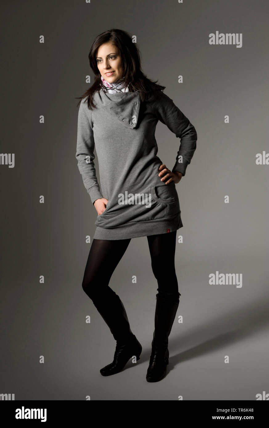 Junge attraktive Frau posiert in ein graues Longshirt Stockfoto