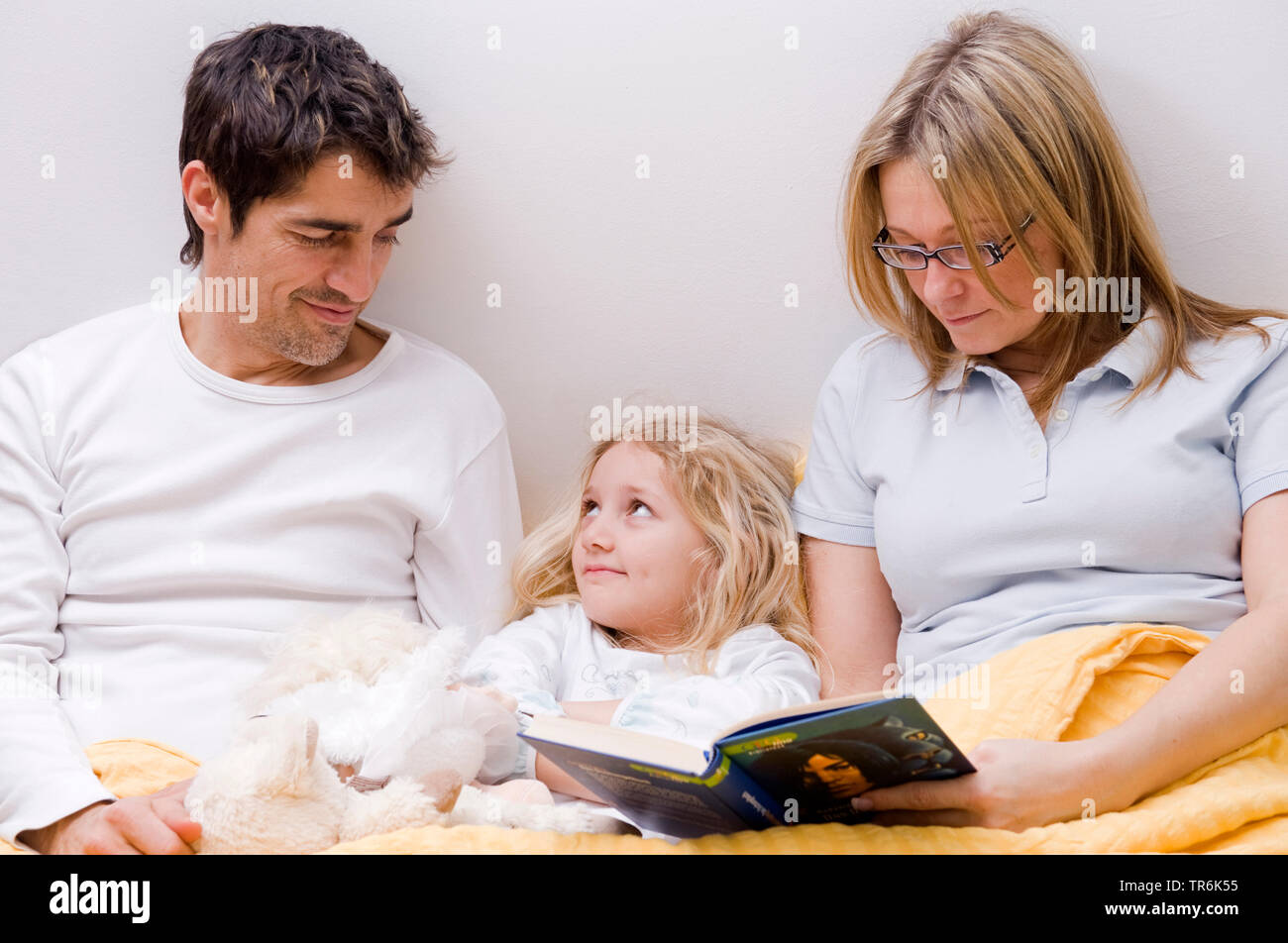 Eltern und Tochter zusammen in einem Bett Stockfoto
