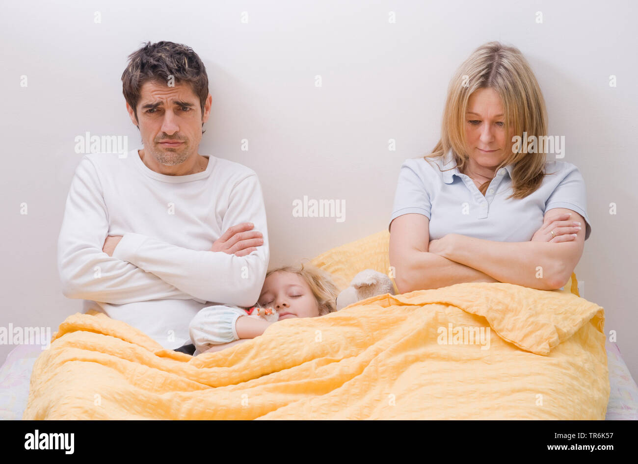 Tochter, die zwischen den Eltern im Bett schlafen Stockfoto