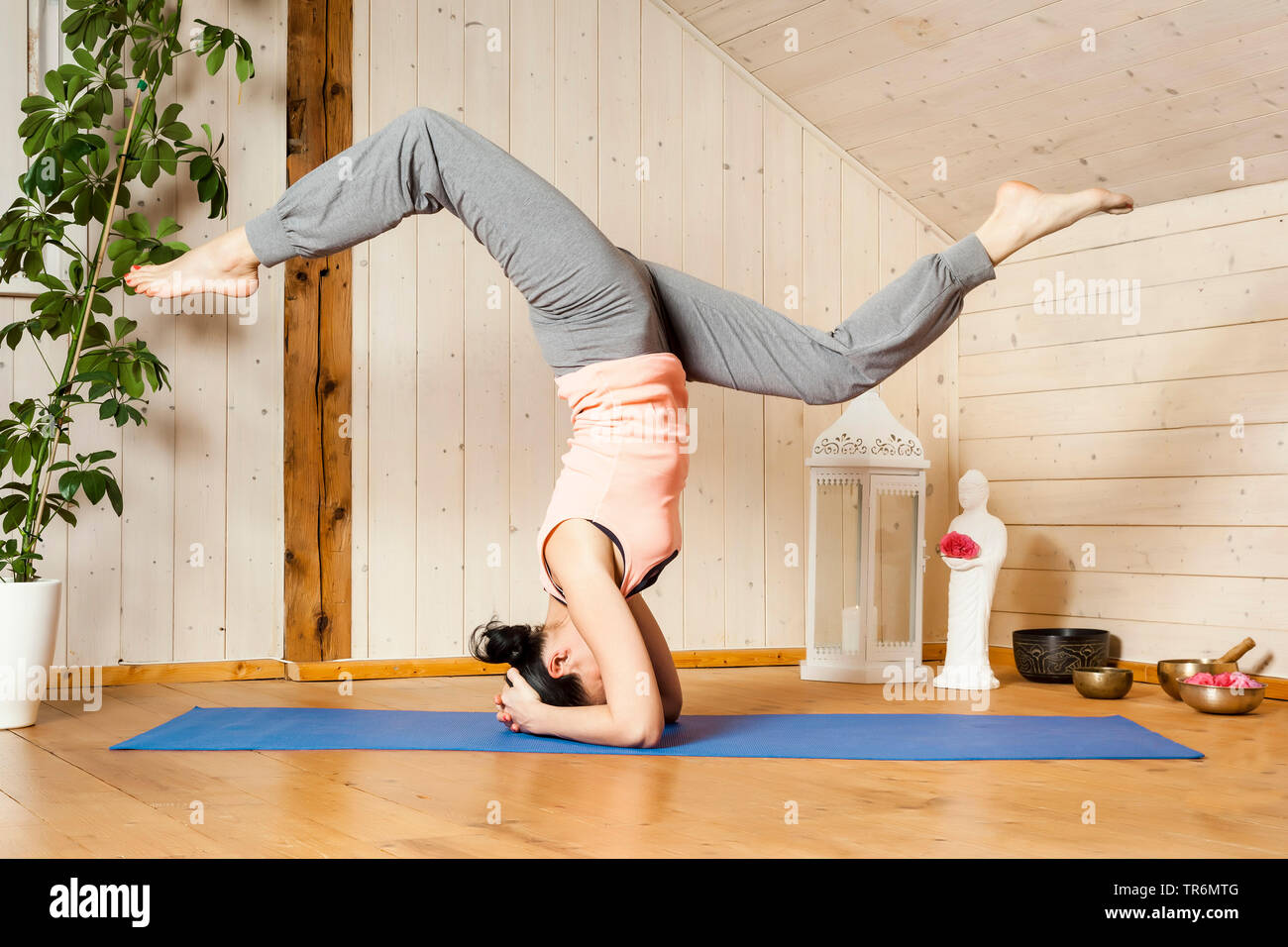 Frau Yoga auf eine Yoga Matte in der flachen, Kopfstand, Deutschland Stockfoto