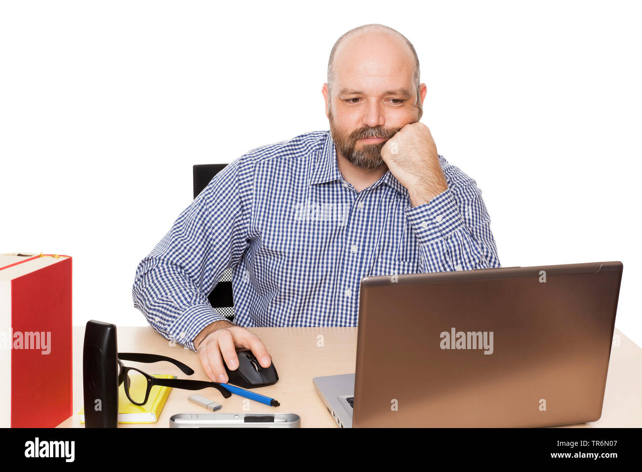 Mann mit Bart am Schreibtisch mit Laptop, Surfen, Aussparung sitzen, Deutschland Stockfoto