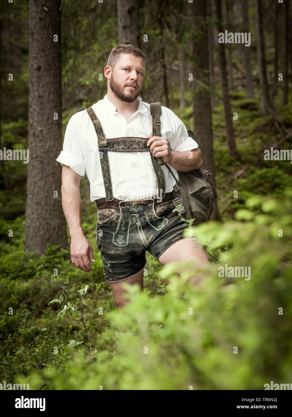 Junger Mann mit bayerische Lederhose wandern im Wald, Deutschland, Bayern Stockfoto