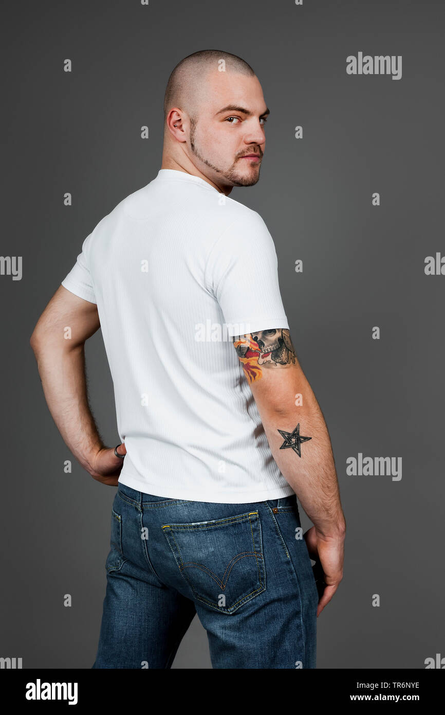 Jungen tätowierten Mann in T-Shirt und Jeans, Deutschland Stockfoto