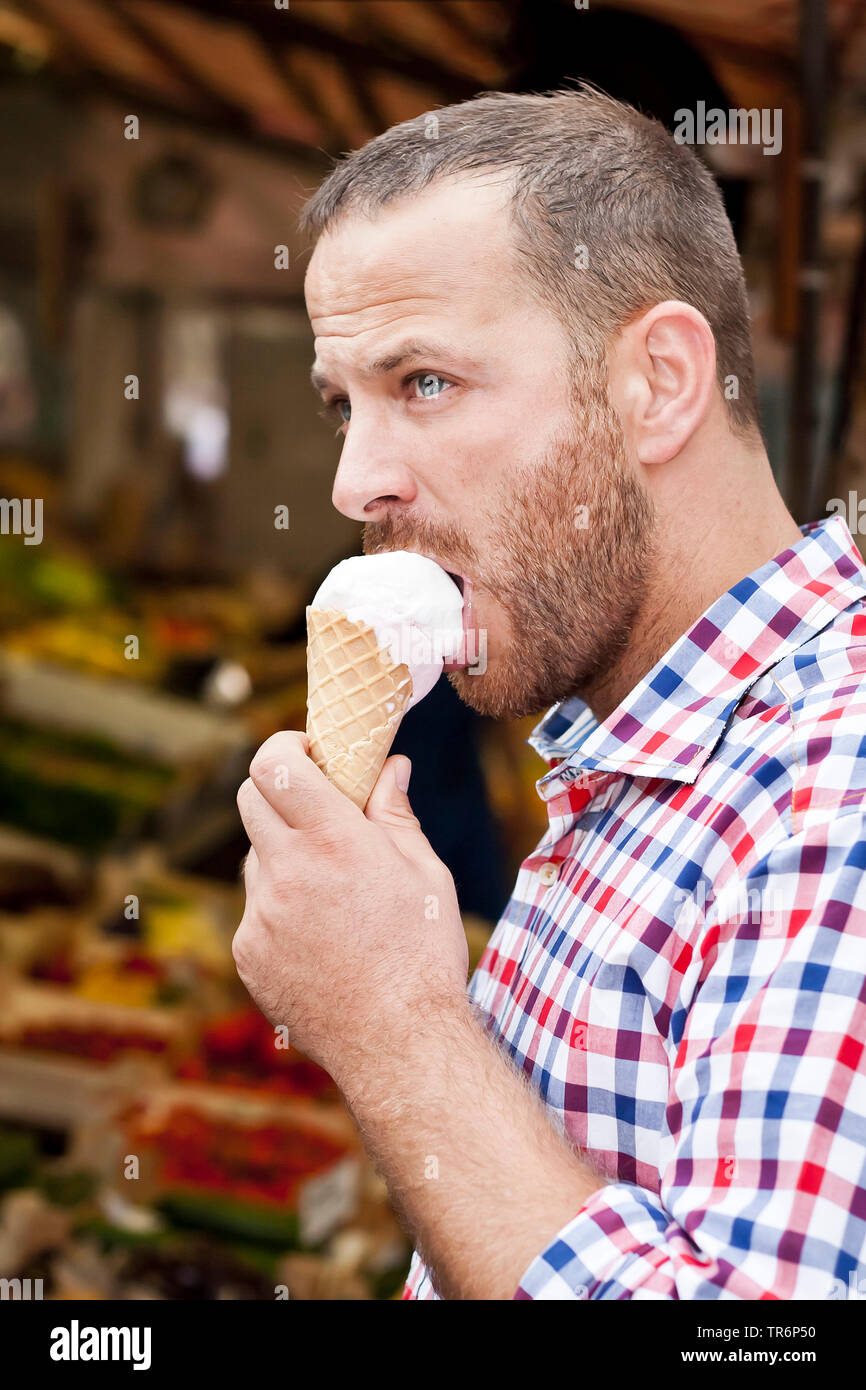 Stattlicher Mann mit Bart ein Eis essen, Deutschland Stockfoto