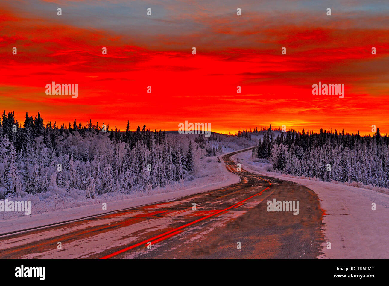 Landstraße im Schnee Landschaft bei Sonnenuntergang, USA, Alaska, haines Alaska Chilkoot Fluss Stockfoto