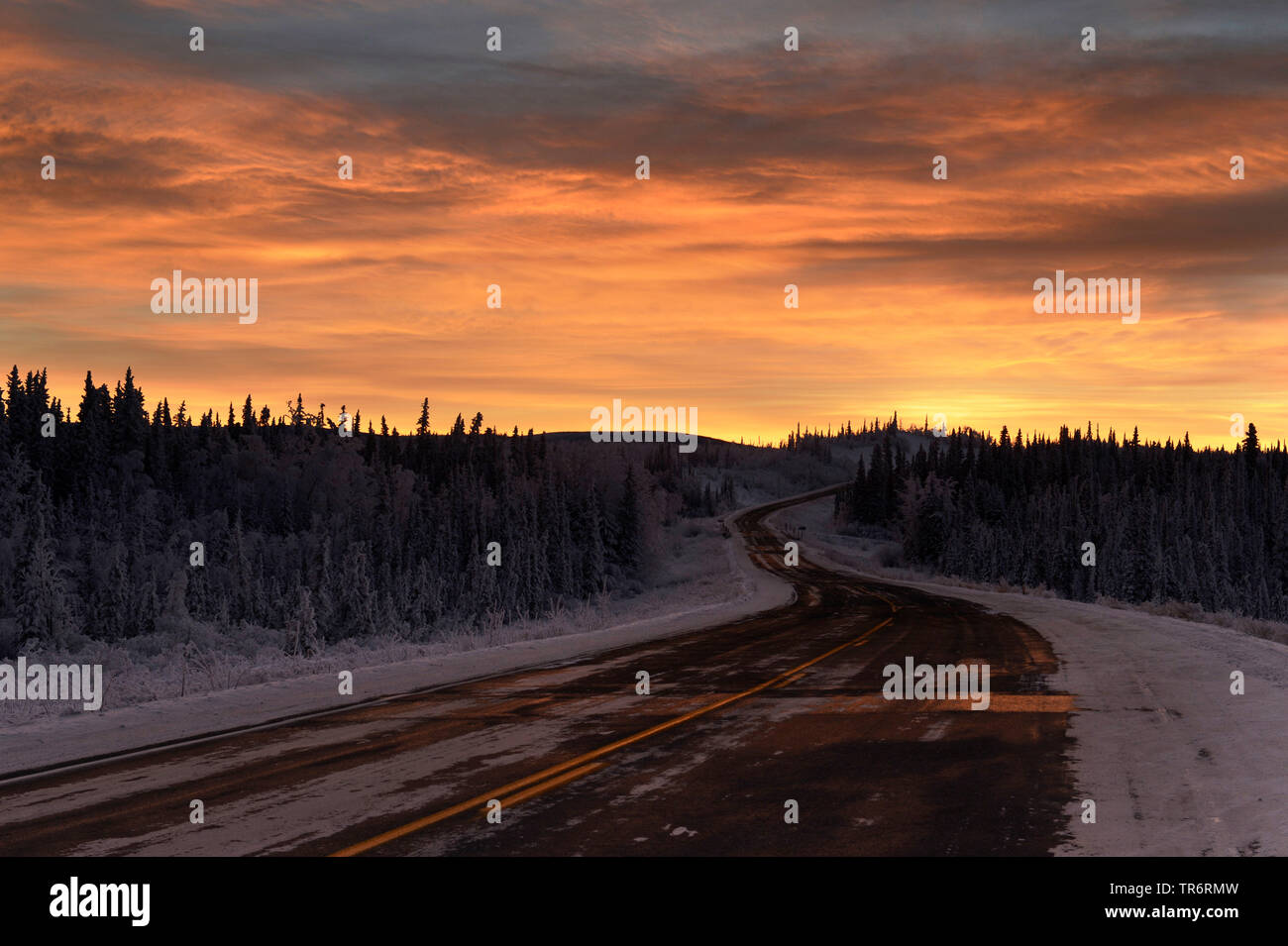 Landstraße im Schnee Landschaft bei Sonnenuntergang, USA, Alaska, haines Alaska Chilkoot Fluss Stockfoto