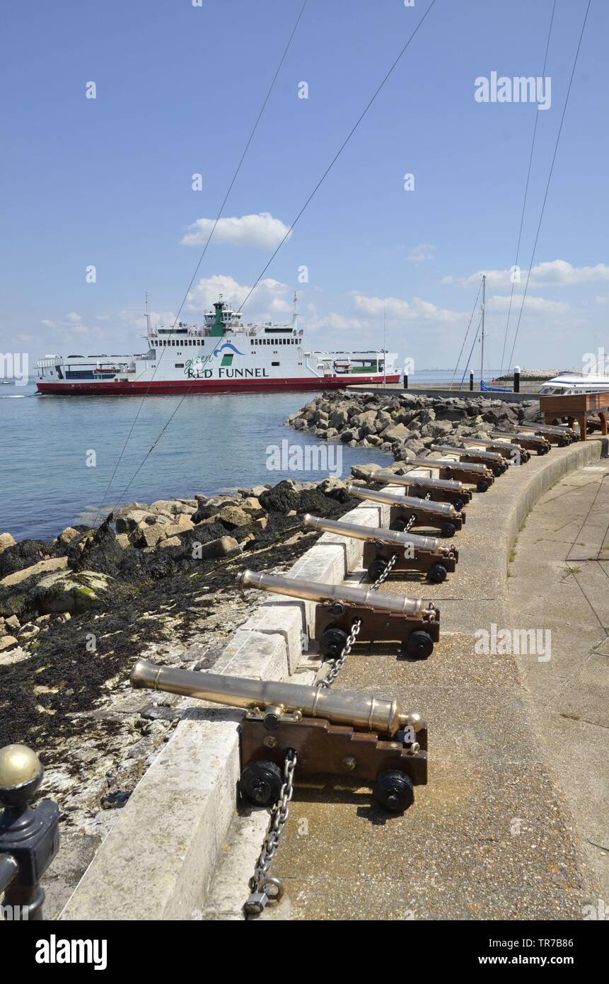 Ein roter Trichter Personenfähre auf dem Solent Köpfe in Cowes auf der Isle of Wight. Dekorative Kanone des Royal Yacht Squadron stehen im Vordergrund. Stockfoto