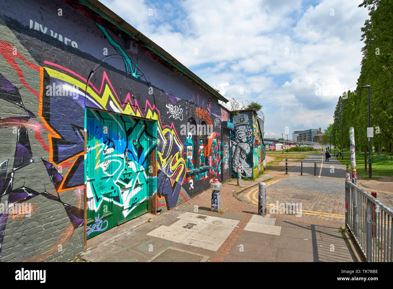 LONDON SPITALFIELDS Brick Lane, GAFFITI UND WALL ART, MIT BLICK AUF DIE BÄUME UND DEN PARK Stockfoto