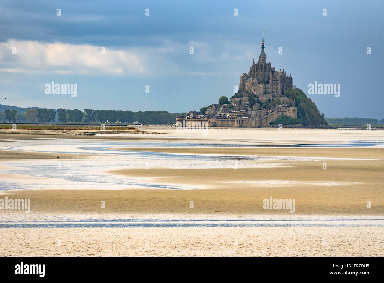 Le Mont St Michel über das Wattenmeer bei Ebbe mit Wolken während des Tages gesehen Stockfoto