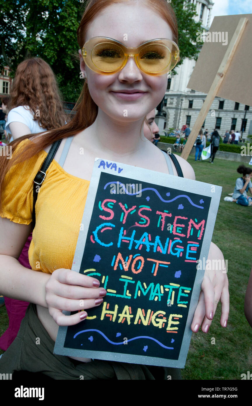Schule Klima Streik, London, England, UK. Ein Mädchen tragen gelbe Sonnenbrille hält ein Schild mit der Aufschrift 'System ändern nicht den Klimawandel". Stockfoto