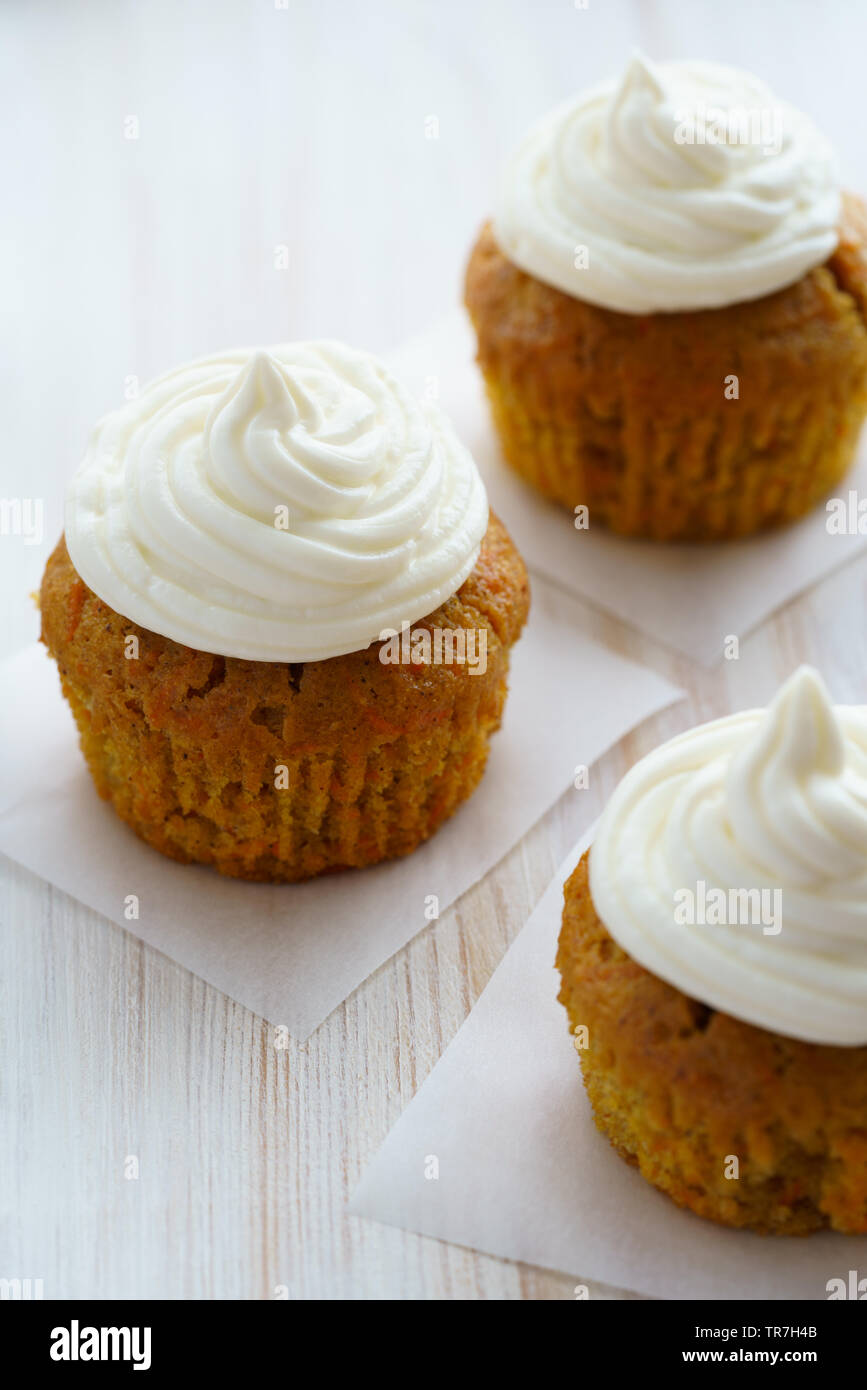 Karotte Cupcakes mit Vanille Glasur. Weiße Holztisch, hohe Auflösung Stockfoto