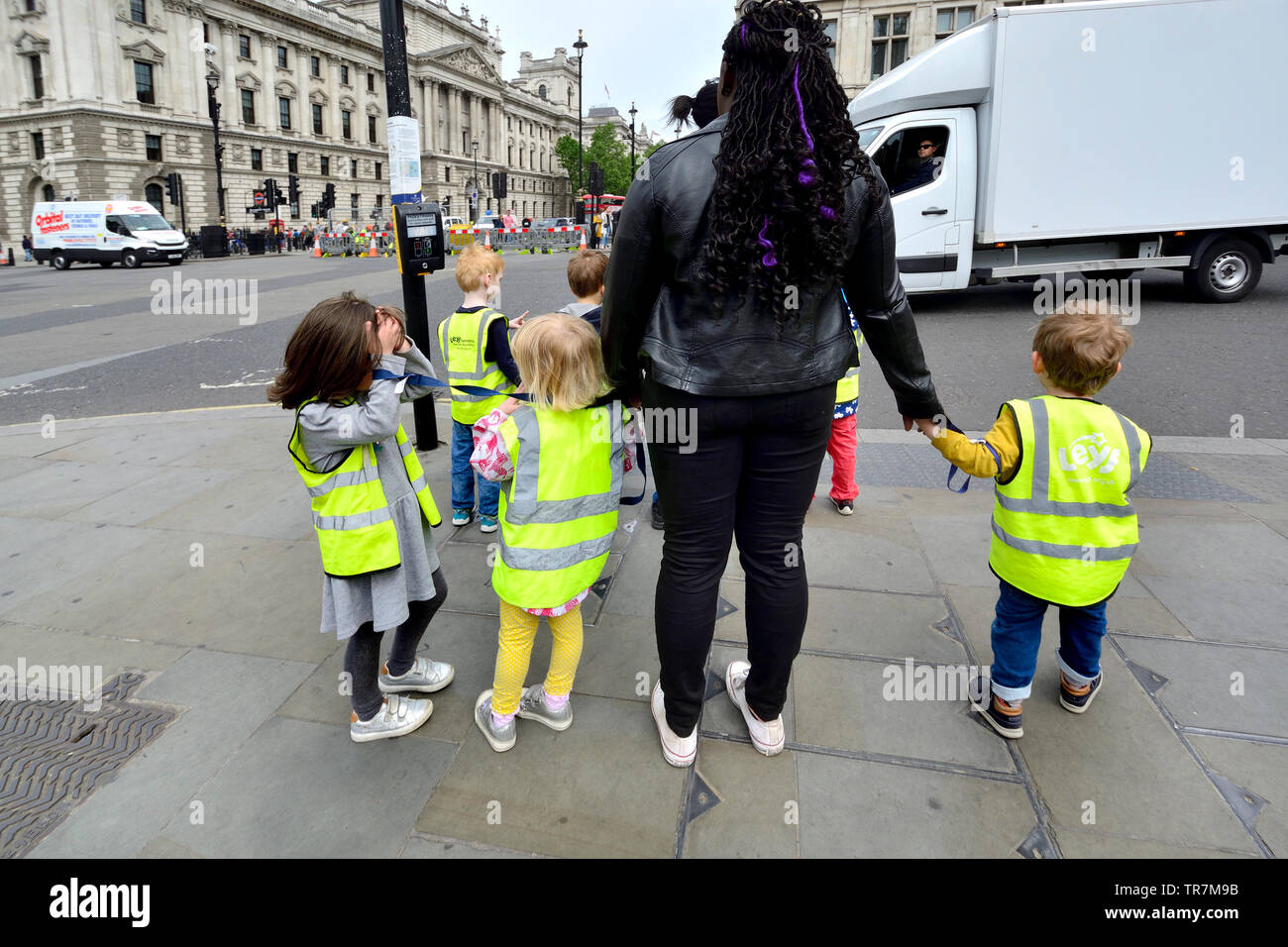 London, England, UK. Gruppe junger Kinder warten die Straße überqueren Stockfoto
