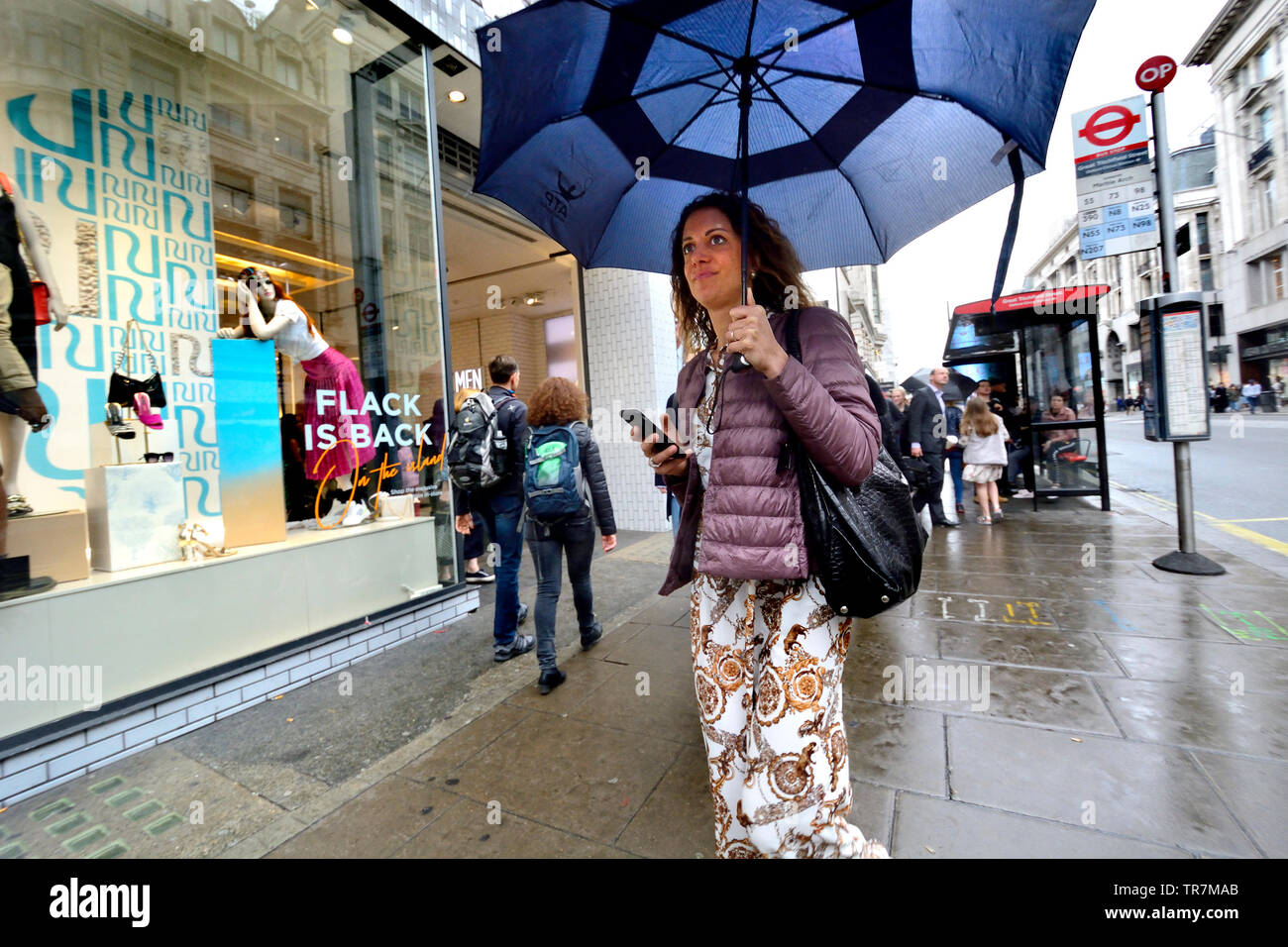 London, England, UK. Leute, Shopping in der Oxford Street an einem regnerischen Tag Stockfoto