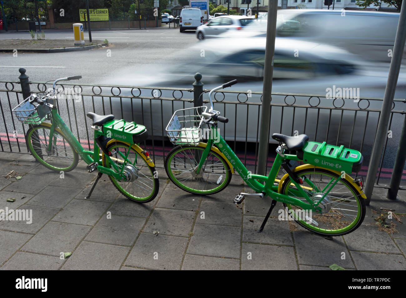 Ein paar dockless Kalk ebikes durch den geschäftigen chalkers Ecke Kreuzung im Südwesten von London geparkt, England Stockfoto
