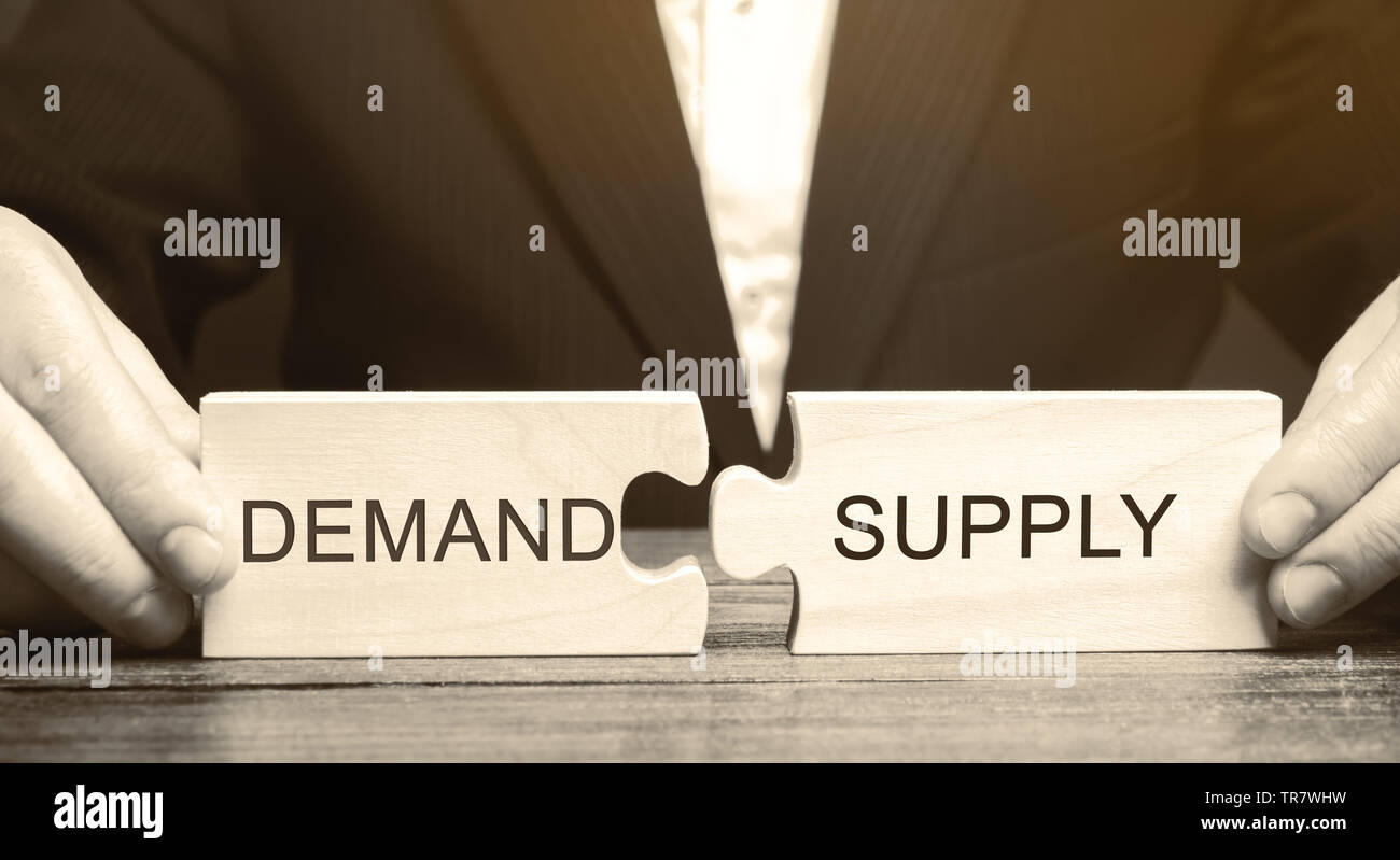 Geschäftsmann sammelt Puzzles aus Holz mit dem Wort Angebot und Nachfrage. Das Konzept des Arbeitsmarktes. Die ökonomische Theorie, Beziehungen. Business- und Kom Stockfoto
