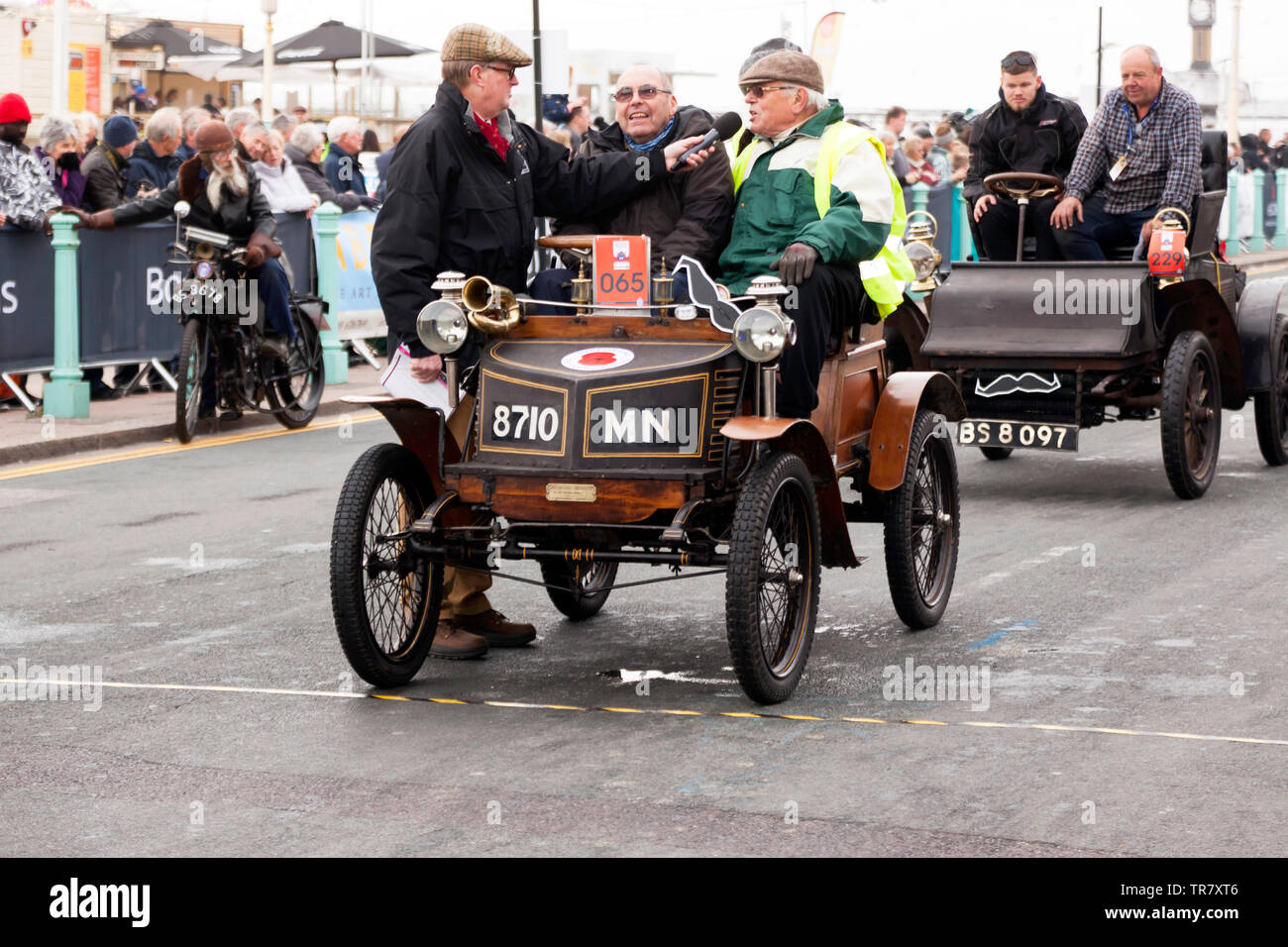 Herr Nicholas Cussons Fahren seines 1900 in New Orleans, während der Beifahrer interviewt wird, am Ende der London 2018 nach Brighton Veteran Car Run Stockfoto