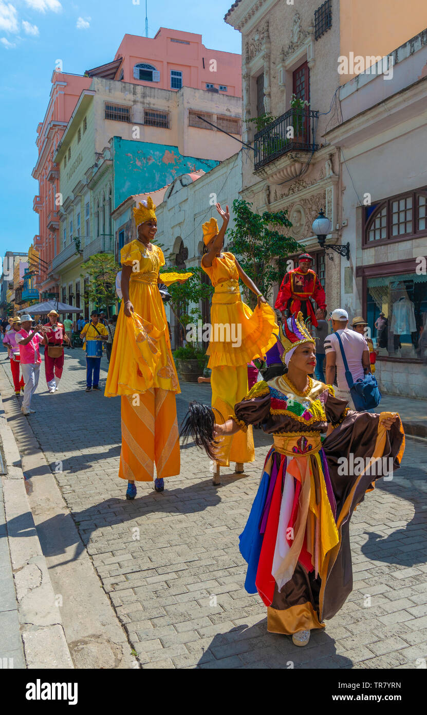 Farbenfroh gekleideten Straßenkünstler in der Altstadt von Havanna, Kuba, manche auf Stelzen mit einer Band spielen folgende an der Rückseite. Stockfoto