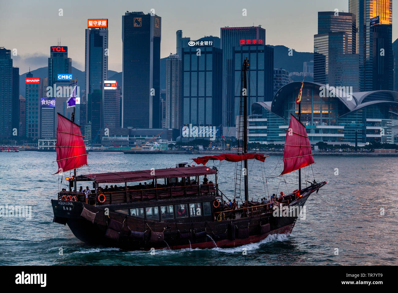 Ein Aqua Luna Junk Bootsfahrt auf Victoria Harbour und die Skyline von Hongkong, Hongkong, China Stockfoto