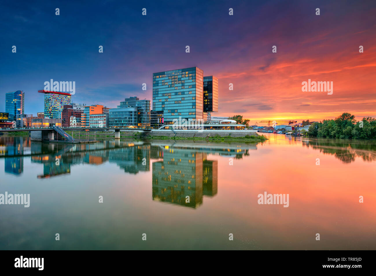 Düsseldorf, Deutschland. Stadtbild von Düsseldorf mit dem Medienhafen und Spiegelbild der Stadt im Rhein, in der Dämmerung. Stockfoto