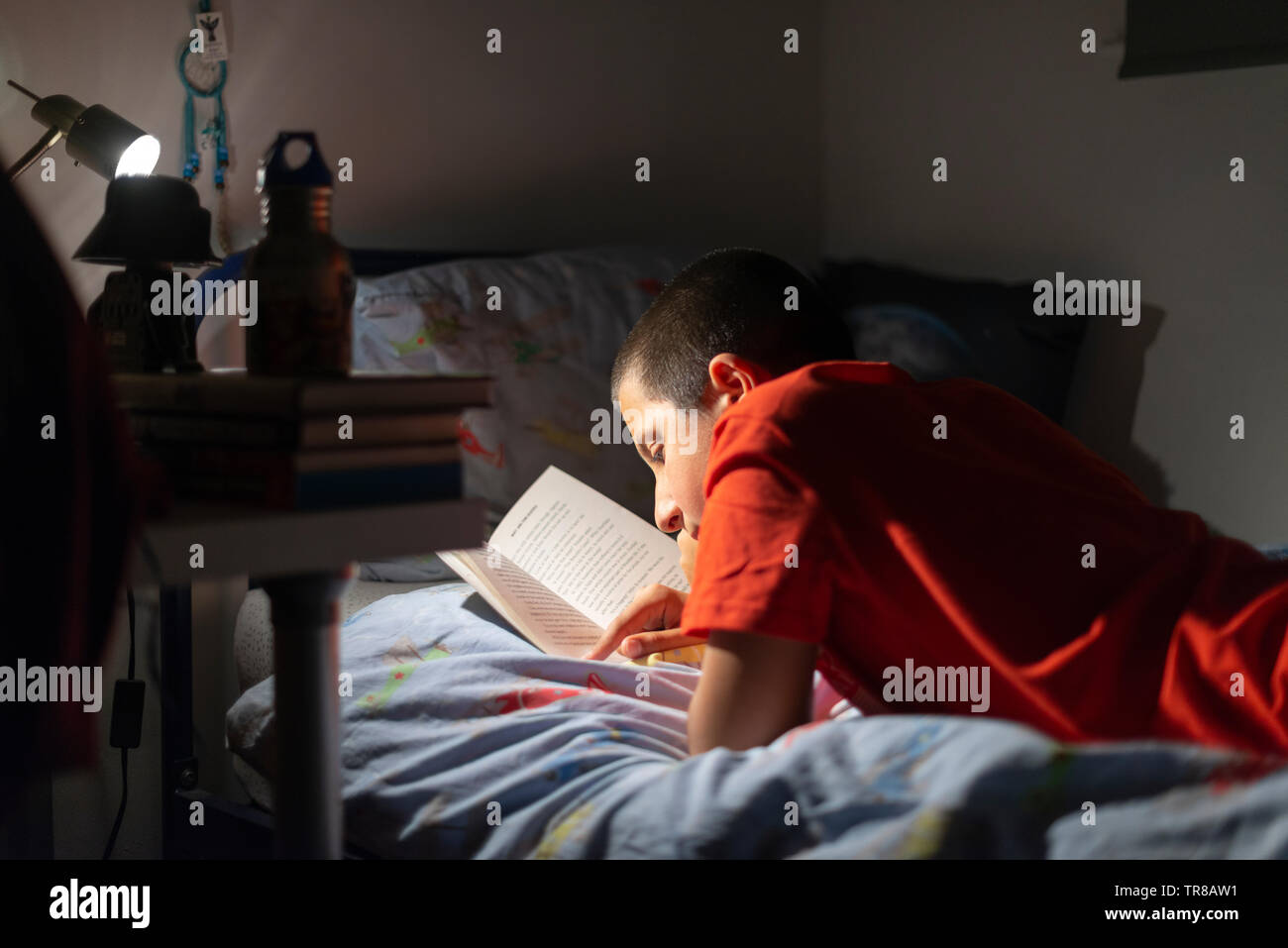 Junge liest im Bett Stockfoto