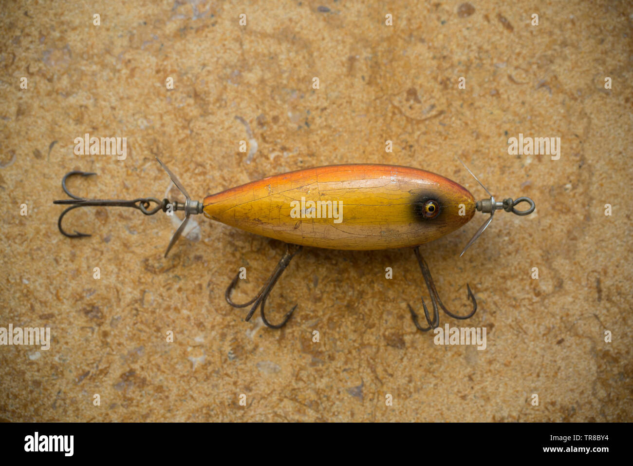 Eine alte South Bend Fischen lure fotografiert auf einem Stein. Köder wie diese sind oft als Stecker dieser seiend mit drei großen ausgestattet Stockfoto