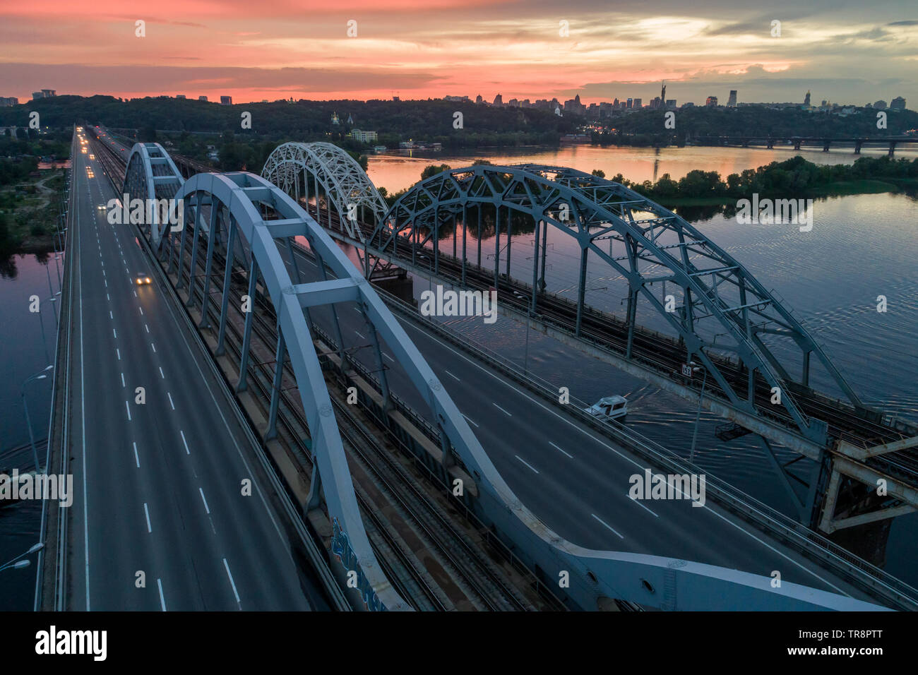 Sonnenuntergang Luftaufnahme auf einem Darnitsky Brücke, großen Fahrzeug und Eisenbahn Transport weg in Kiew, Ukraine Stockfoto