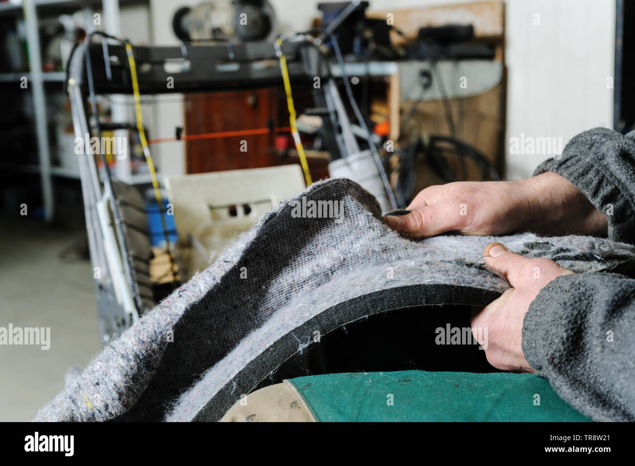 Reparatur der Autositzheizung. Die Hände des Automechanikers demontieren die Polsterung eines Stuhls, um ein Heizkabel zu erreichen. Stockfoto