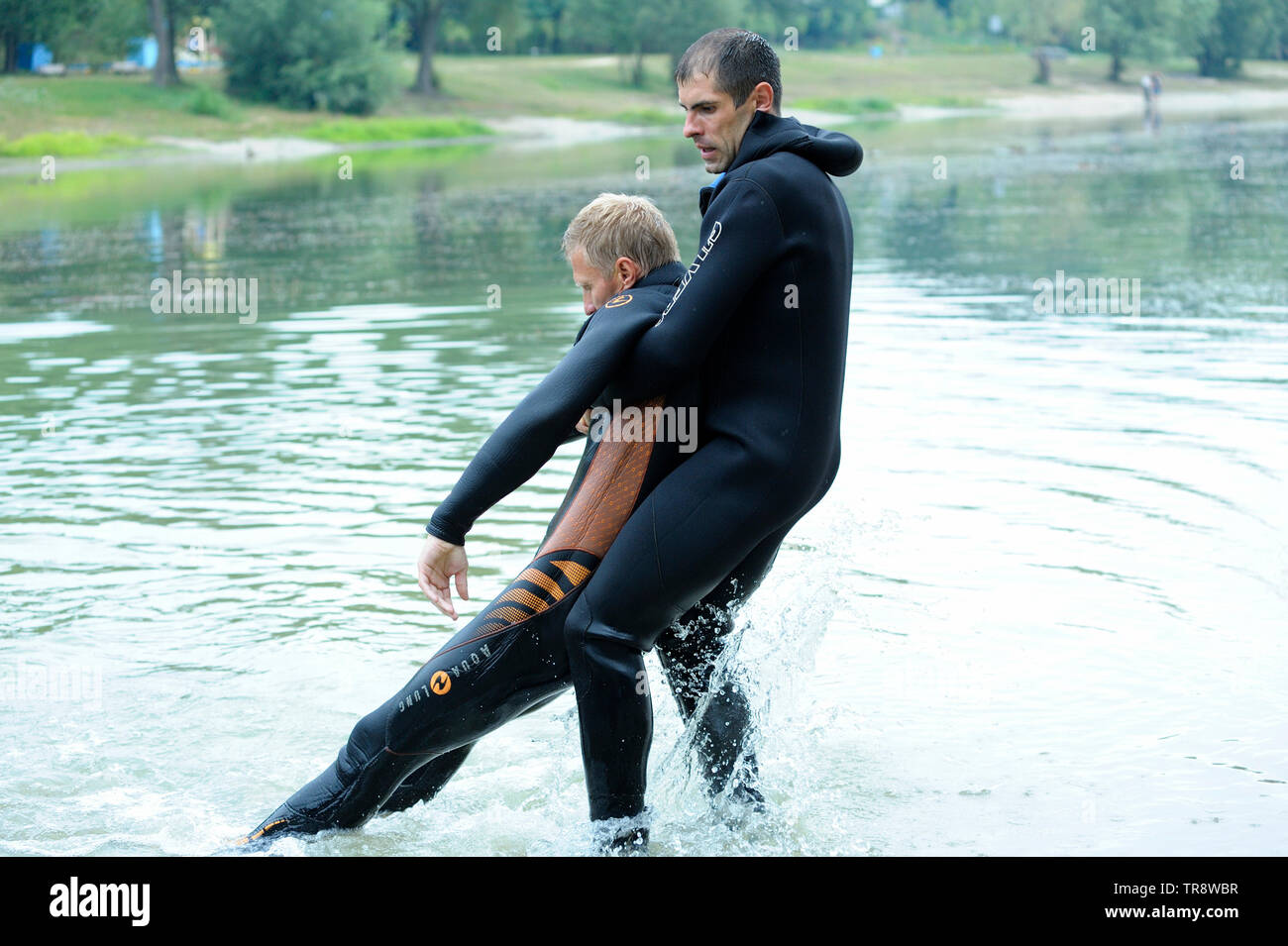 Männer, die in einem nassen Diver suit (Rettungsschwimmer), die die richtige Herausziehen ertrinken aus dem Wasser. August 10,2018. Kiew, Ukraine Stockfoto