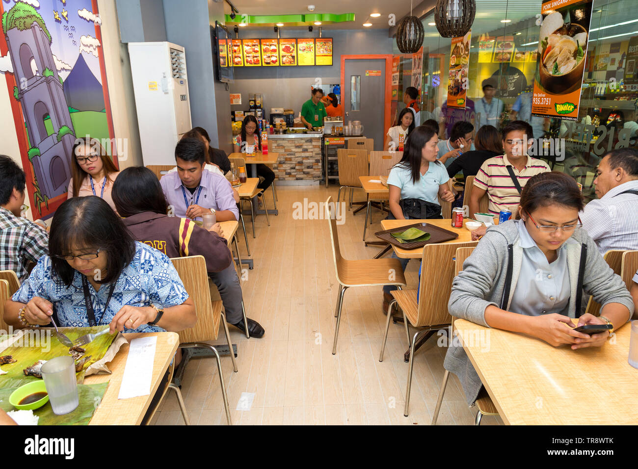 Manila, Philippinen - Juli, 26, 2016: Die Menschen essen Mittagessen in einem populären philippinischen Fast-Food-Kette Stockfoto