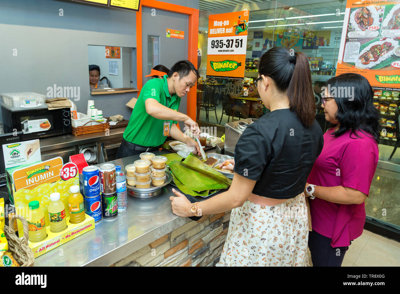 Manila, Philippinen - Juli 26, 2016: Zwei weibliche Kunden Essen bestellen an der Kasse in eine philippinische Restaurant Stockfoto