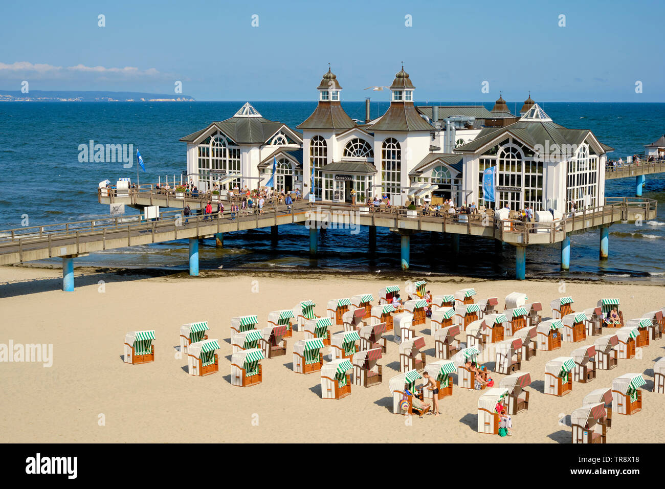 Liegestühle am Strand und die Seebrücke Sellin Ostseebad auf der Insel Rügen Deutschland. Seebrücke (Pier) mit einem im Stil der 1920er Jahre Pavillon. Stockfoto