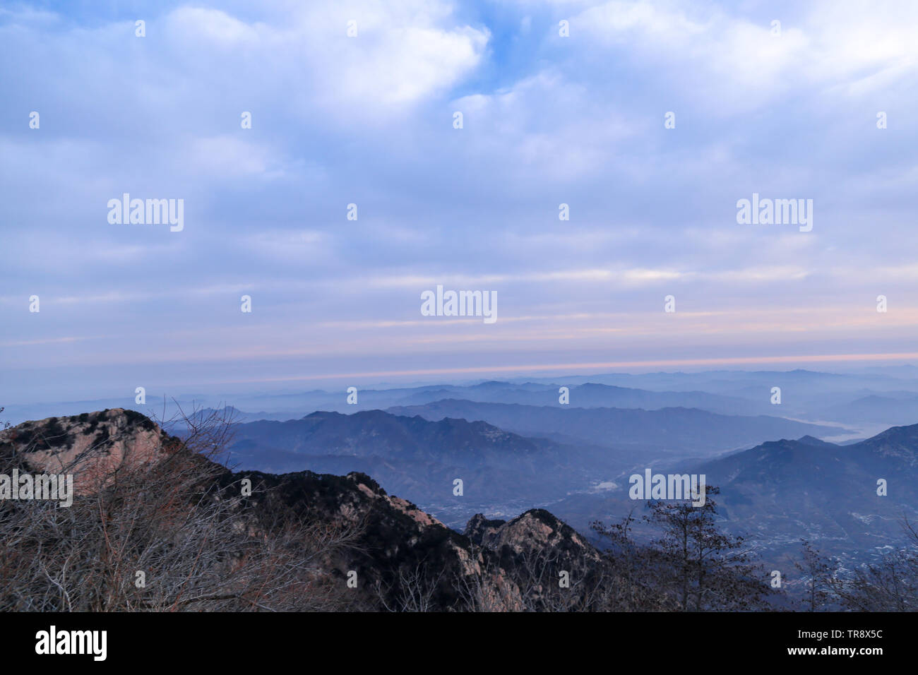 Felsen und Schnee auf den Gipfeln der Berge in der Ferne ragte. Die Wolken im Himmel dick waren und hieven. Bergen aufgetürmt Stockfoto