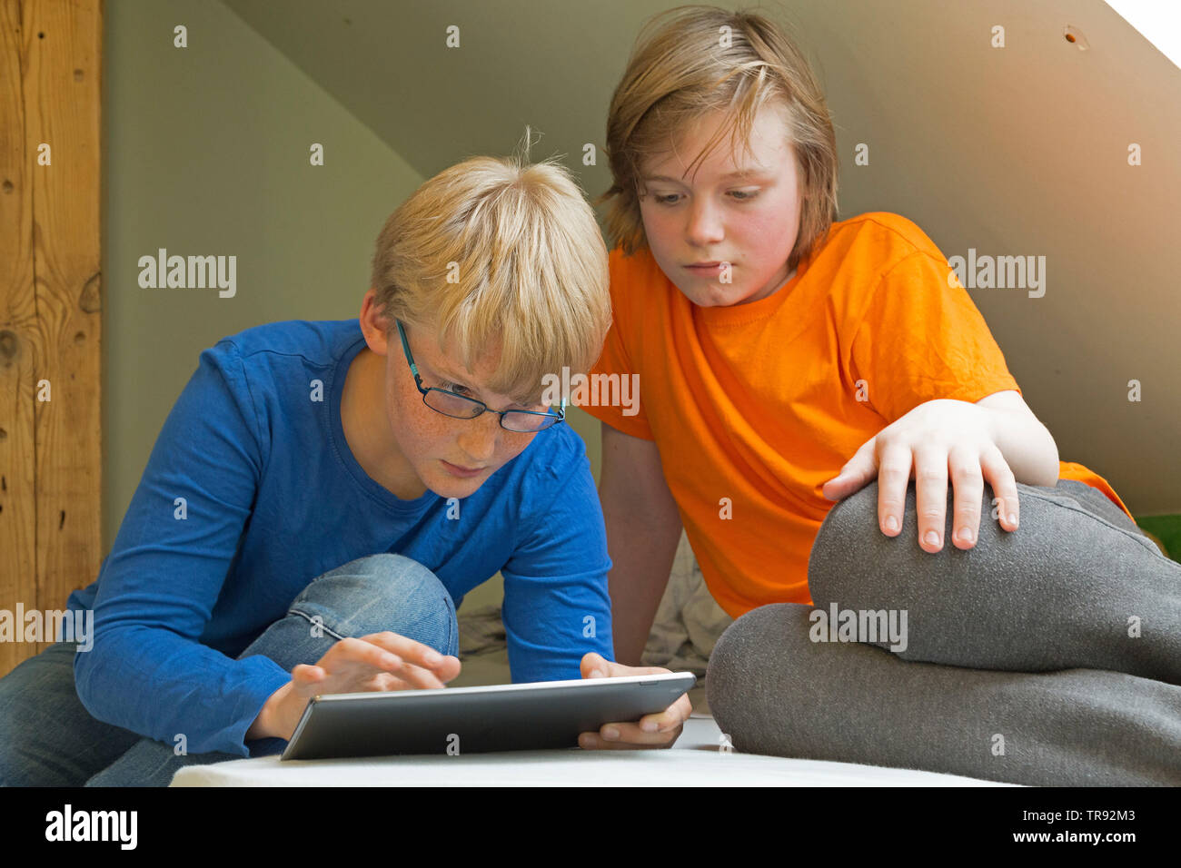 Junge plyaing mit Tablet Computer, sein Freund aufpassen, Deutschland Stockfoto