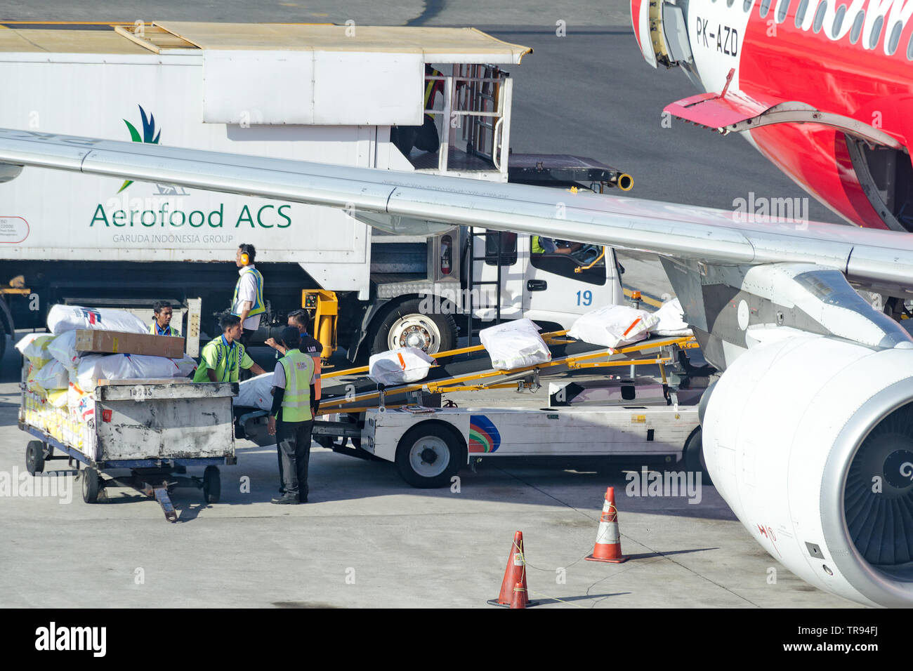 Bali, Denpasar, 2018-05-01: Flughafen Arbeitnehmer laden Gastronomiebedarf in Flugzeugen. Das Bodenpersonal stellt die Verpackung mit Nahrungsmitteln aus Aerofood ACS Stockfoto